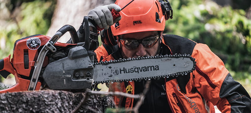 Husqvarna pro chainsaw resting on fallen tree