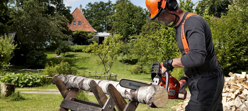 Man using Husqvarna chainsaw with PPE