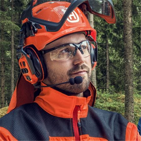 Man wearing Husqvarna PPE Helmet, hearing protection and gloves